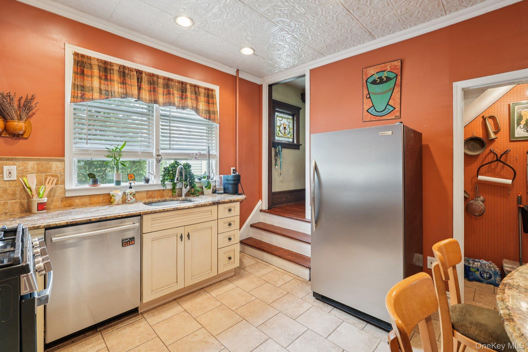 74 East Maple Avenue Suffern, NY 10901 - Photo 14 of 50 Kitchen featuring ornamental molding, appliances with stainless steel finishes, light stone countertops, an ornate ceiling, and cream cabinets