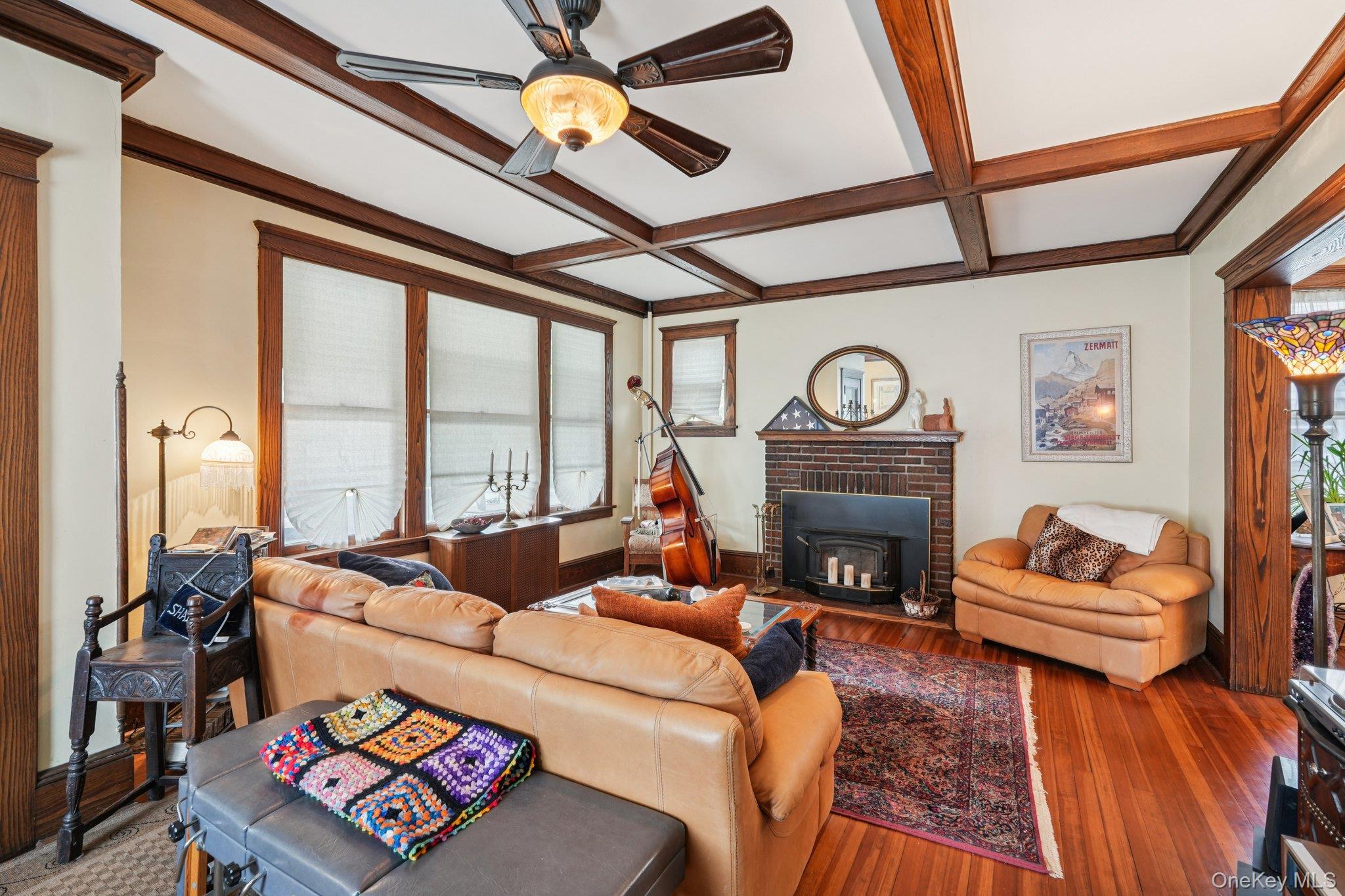 74 East Maple Avenue Suffern, NY 10901 - Photo 4 of 50 Living room featuring coffered ceiling, beam ceiling, wood finished floors, a ceiling fan, and a wood stove