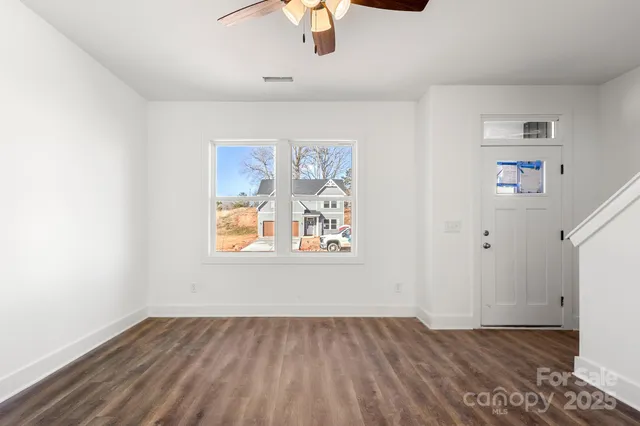 an empty room with wooden floor and window