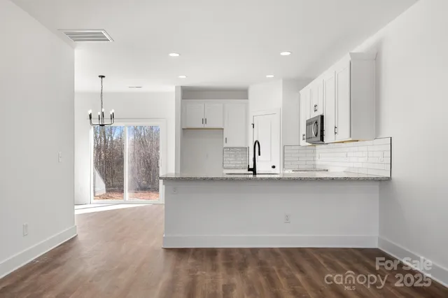 a kitchen with stainless steel appliances granite countertop a sink a stove a refrigerator and cabinets