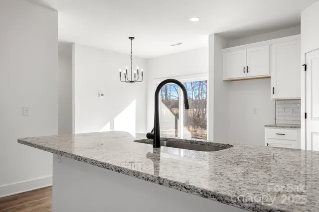 a view of a kitchen counter top a stove and cabinets