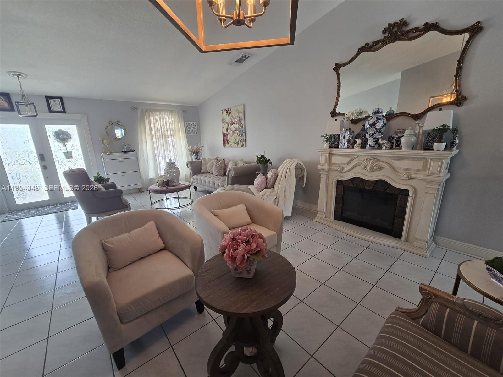15201 Southwest 177th Terrace Miami, FL 33187 - Photo 17 of 49 a living room with furniture a fireplace and a chandelier