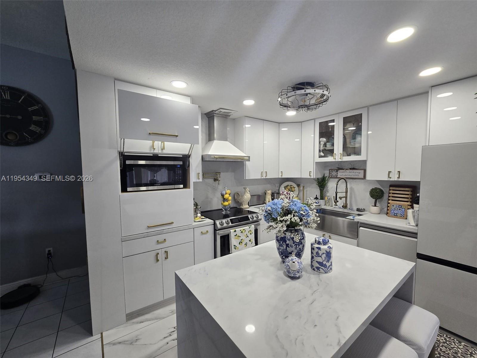 15201 Southwest 177th Terrace Miami, FL 33187 - Photo 26 of 49 a kitchen with a refrigerator a stove top oven a sink dishwasher and dining table with wooden floor