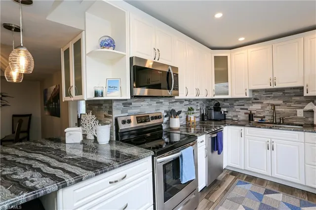 a kitchen with a dining table chairs and view living room