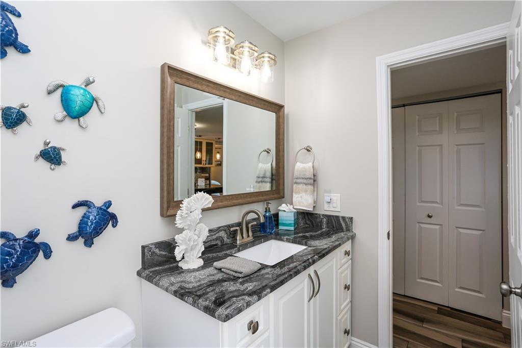 195 Peppermint Lane, Unit 884 Naples, FL 34112 - Photo 23 of 50 a bathroom with a granite countertop sink and a mirror