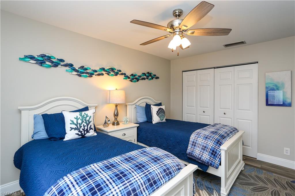 195 Peppermint Lane, Unit 884 Naples, FL 34112 - Photo 25 of 50 a bedroom with a large bed and a chandelier