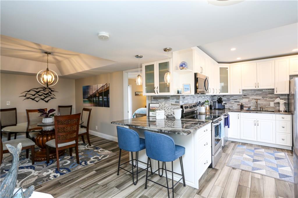 195 Peppermint Lane, Unit 884 Naples, FL 34112 - Photo 29 of 50 a kitchen with a dining table chairs and view living room