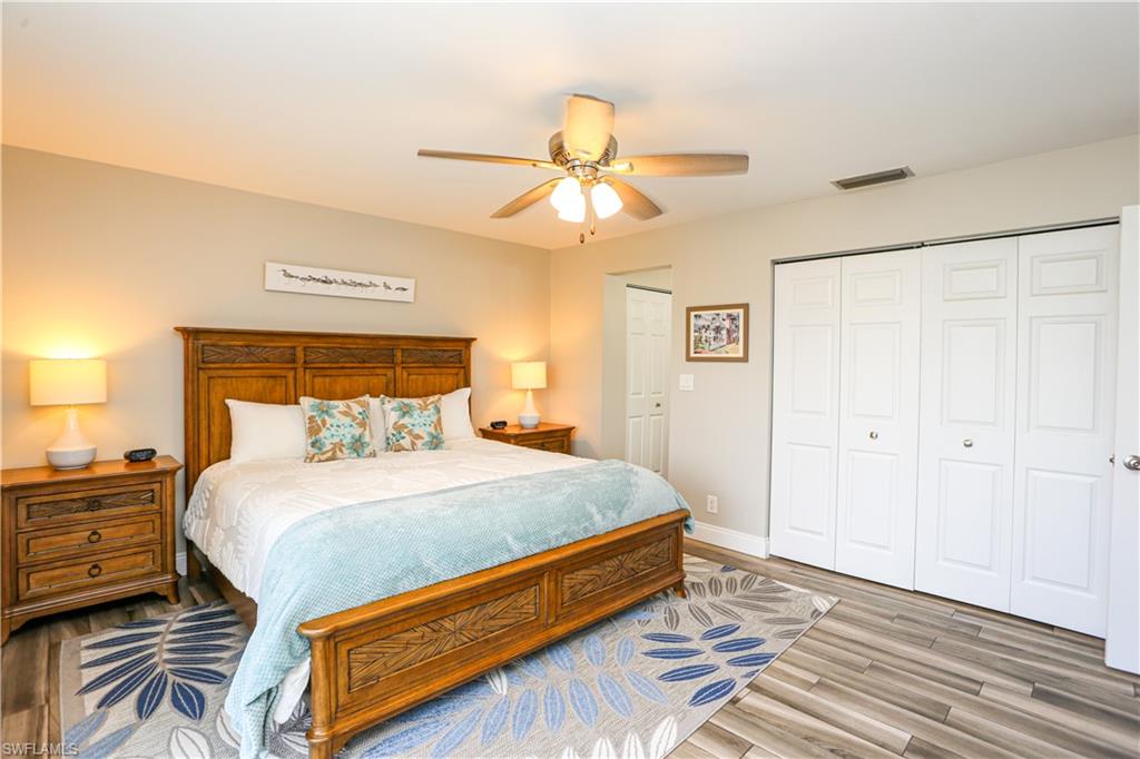 195 Peppermint Lane, Unit 884 Naples, FL 34112 - Photo 39 of 50 a bedroom with a bed and wooden floor