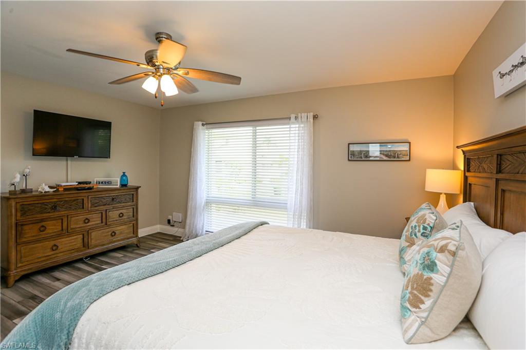 195 Peppermint Lane, Unit 884 Naples, FL 34112 - Photo 41 of 50 a bedroom with a bed and a flat screen tv