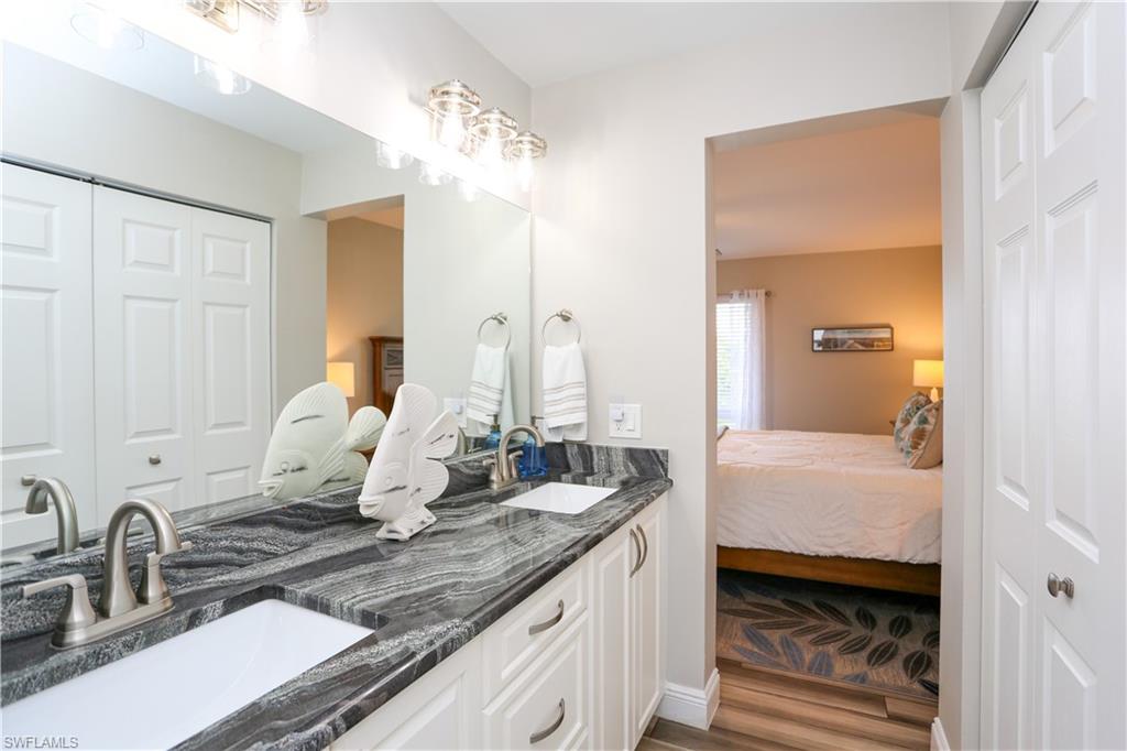 195 Peppermint Lane, Unit 884 Naples, FL 34112 - Photo 45 of 50 a bathroom with a double vanity sink and mirror