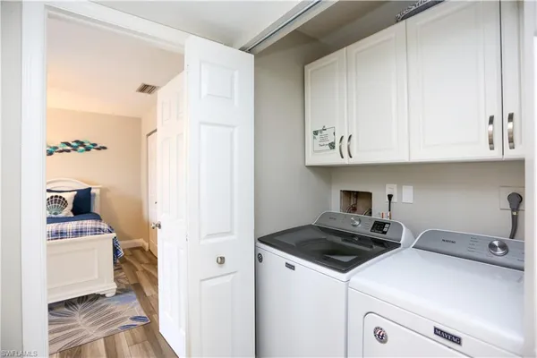 a kitchen with stainless steel appliances granite countertop a stove a sink dishwasher a refrigerator and white cabinets