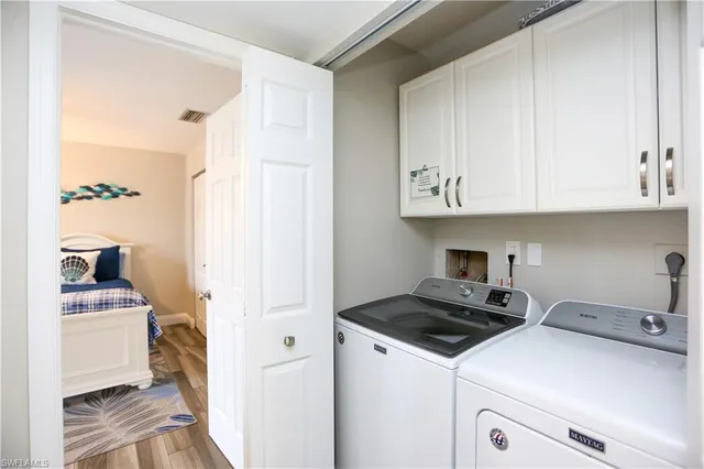 a kitchen with stainless steel appliances granite countertop a stove a sink dishwasher a refrigerator and white cabinets