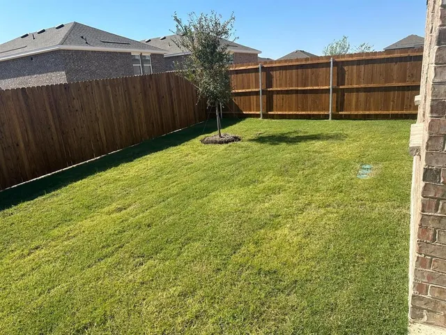 a view of an entrance to house yard and wooden fence