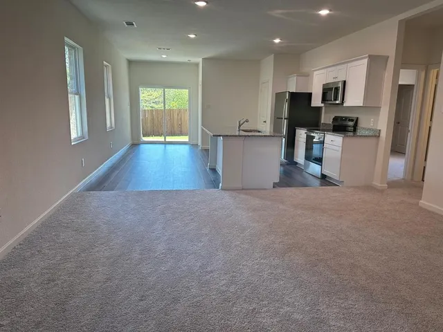 a view of a kitchen with wooden floor and a window