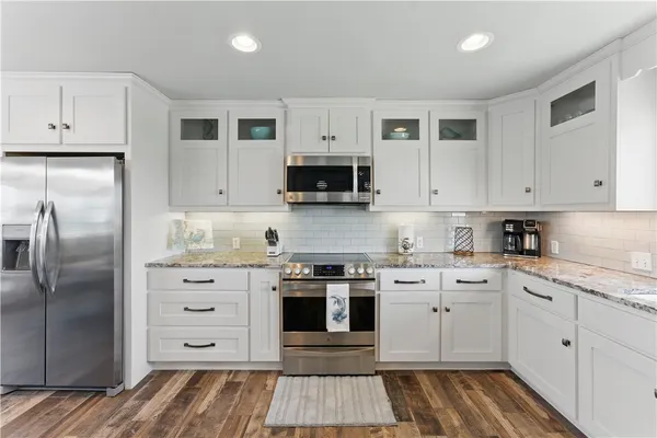 a kitchen with stainless steel appliances granite countertop a stove a sink and a refrigerator
