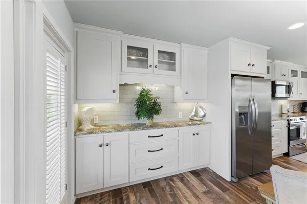 a kitchen with granite countertop a refrigerator and a sink