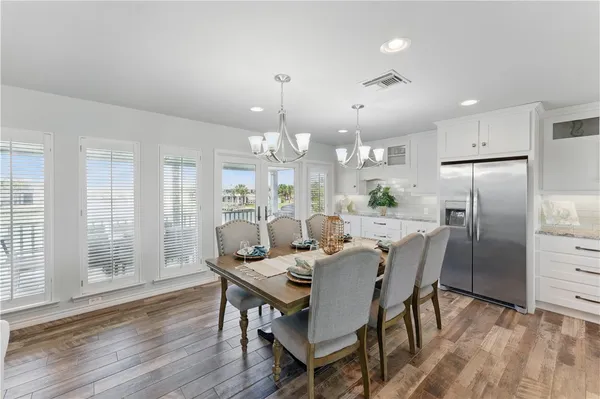 a dining room with furniture a chandelier and wooden floor