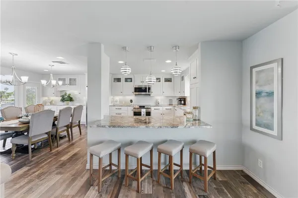 a view of a dining room with furniture wooden floor and kitchen view