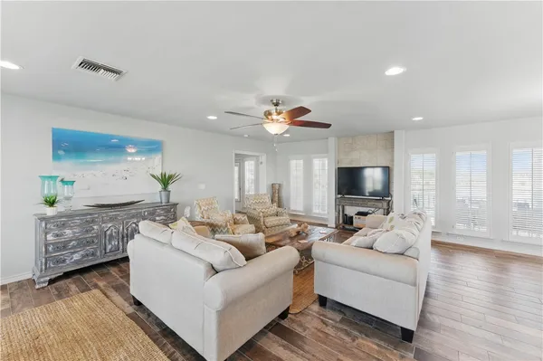 a living room with furniture flat screen tv and wooden floor