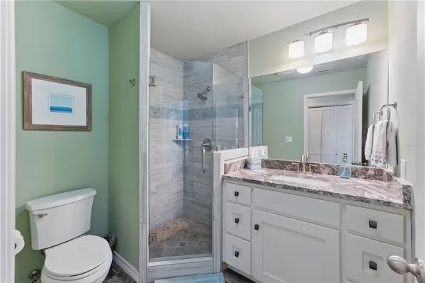 a bathroom with a granite countertop sink toilet and shower