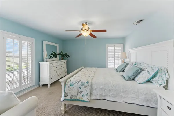 a bedroom with a bed chandelier and a window