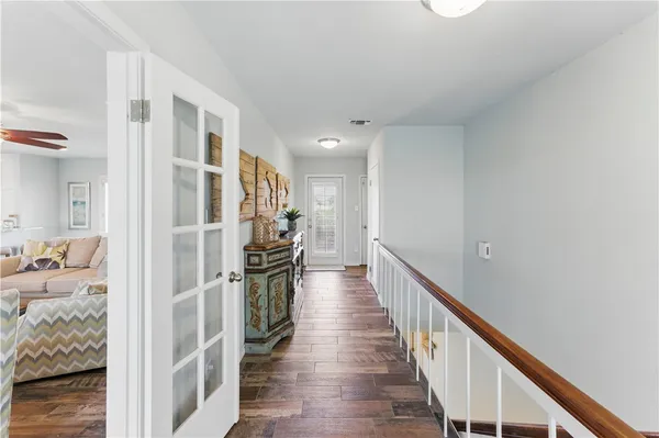 a view of a hallway with wooden floor and windows