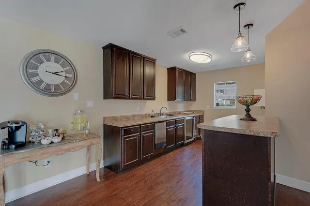 a kitchen with stainless steel appliances granite countertop a stove a sink a refrigerator and wooden floor
