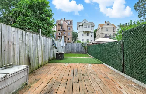 a view of a balcony with wooden floor and fence