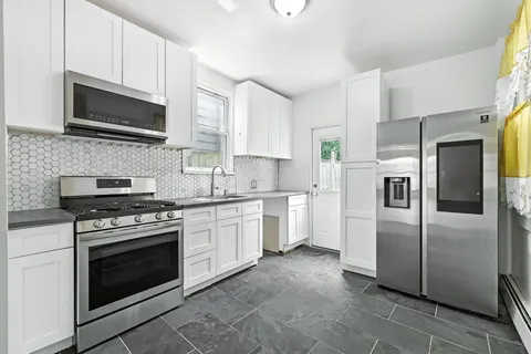 a kitchen with stainless steel appliances granite countertop a stove a refrigerator and a microwave