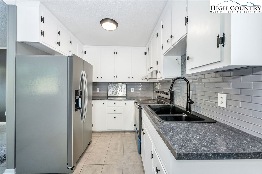 393 Carter Miller Road Todd, NC 28684 - Photo 16 of 50 a kitchen with stainless steel appliances granite countertop a sink stove and refrigerator