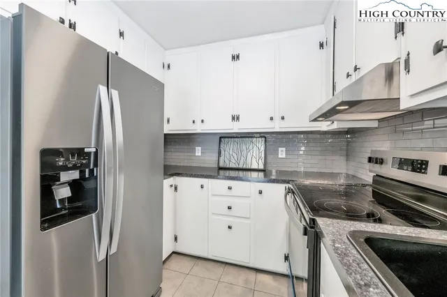 a kitchen with stainless steel appliances white cabinets and white appliances