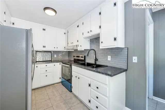 a kitchen with white cabinets appliances and sink