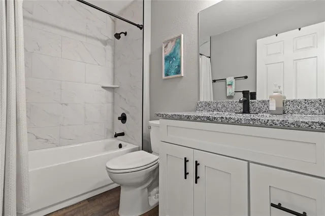 a bathroom with a granite countertop sink toilet and shower