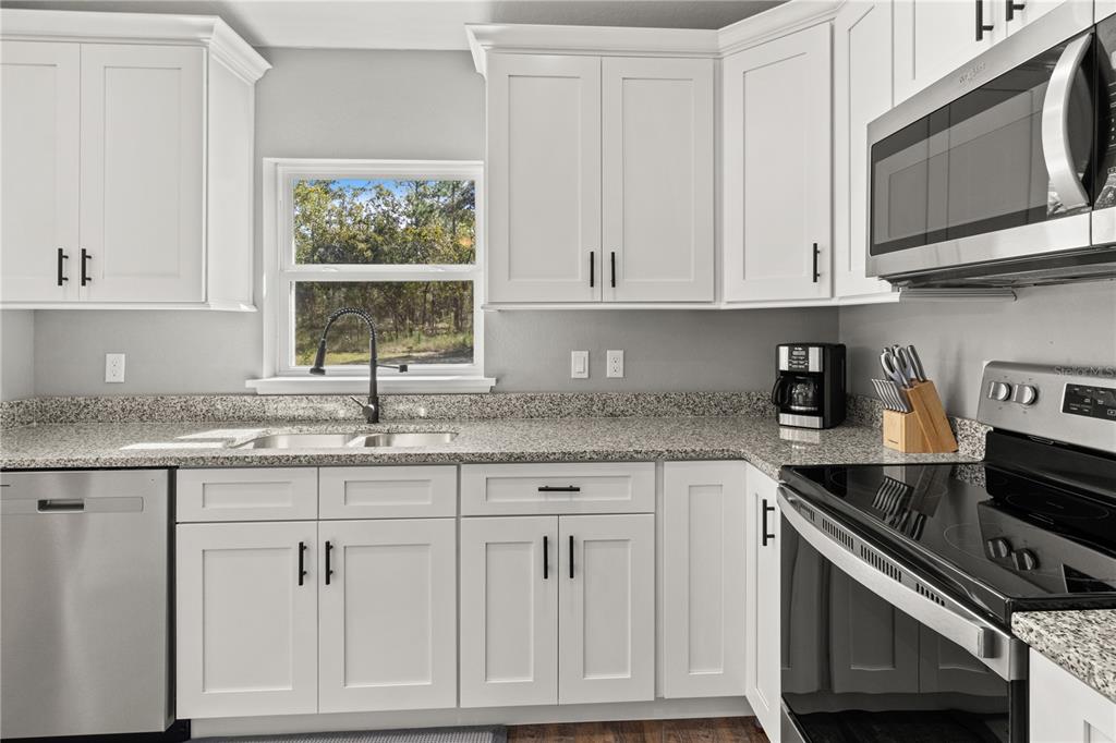 2545 Soundview Drive Dunnellon, FL 34431 - Photo 10 of 23 a kitchen with granite countertop white cabinets and a window