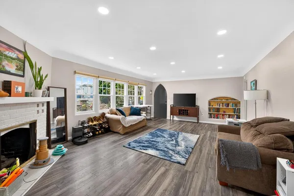 a living room with fireplace furniture and a rug