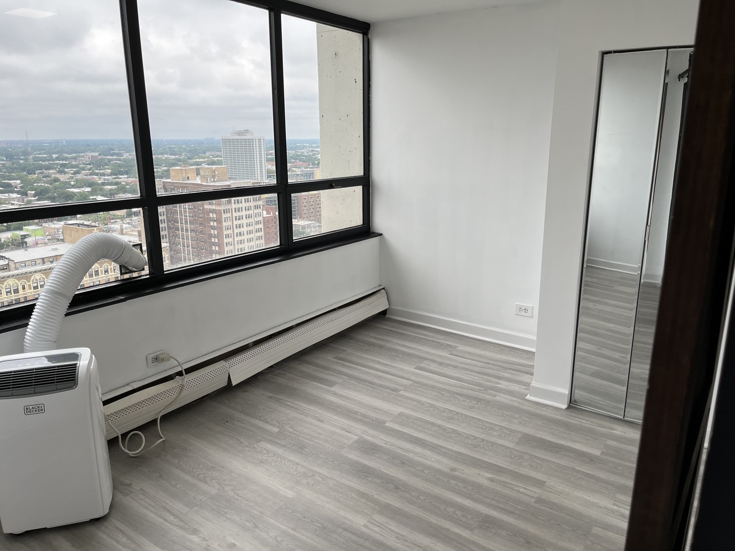 6171 North Sheridan Road, Unit 2502 Chicago, IL 60660 - Photo 16 of 28 an empty room with wooden floor and windows