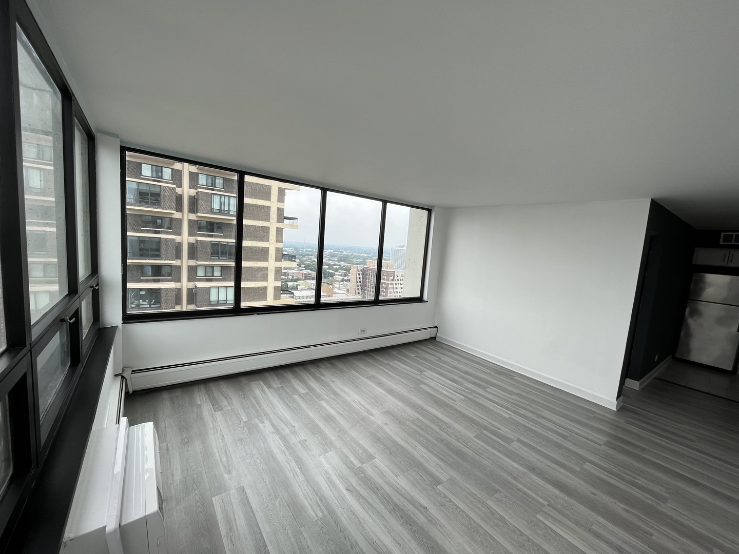 6171 North Sheridan Road, Unit 2502 Chicago, IL 60660 - Photo 5 of 28 wooden floor in an empty room with a window