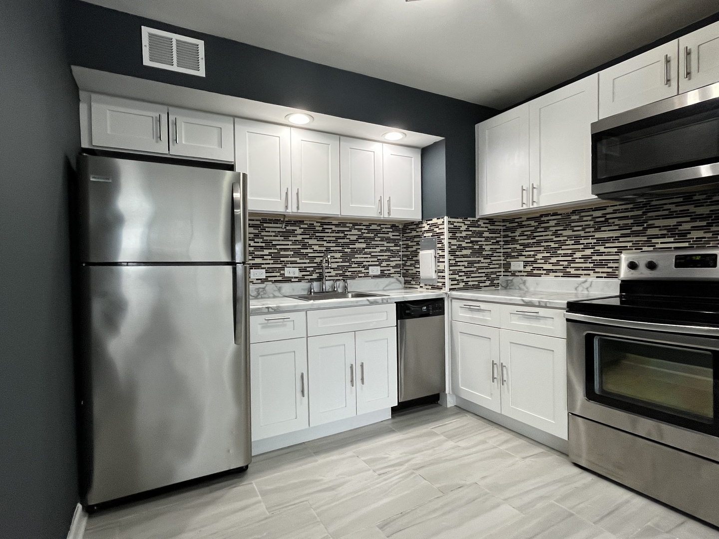 6171 North Sheridan Road, Unit 2502 Chicago, IL 60660 - Photo 10 of 28 a kitchen with a refrigerator stove and microwave