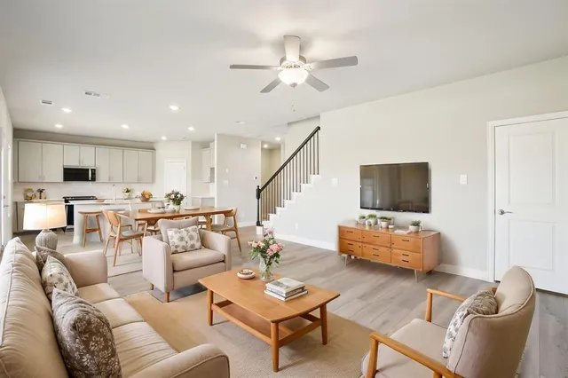 a living room with furniture kitchen view and a flat screen tv