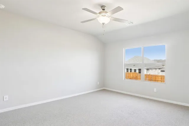 an empty room with a ceiling fan and a window