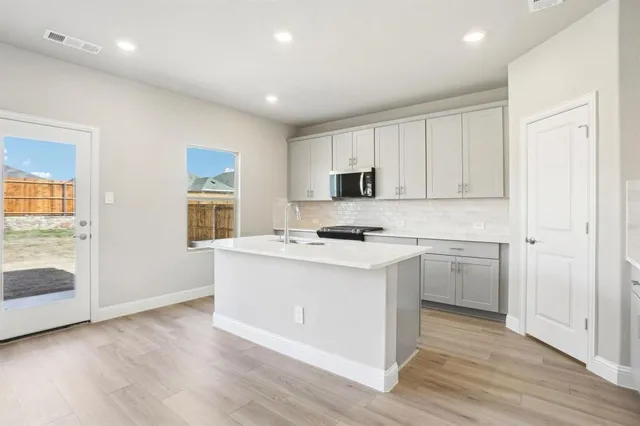 a kitchen with wooden floor and white appliances