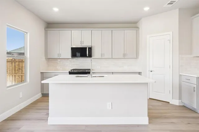 a kitchen with cabinets appliances a sink and a window