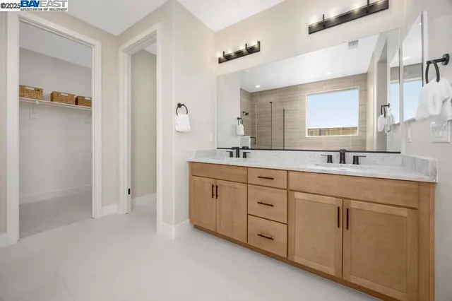 a spacious bathroom with double sink and mirror