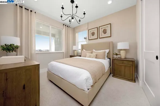 a bedroom with a large bed and a chandelier