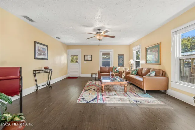 a living room with furniture and a table with wooden floor
