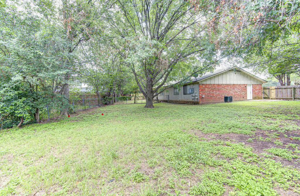 5301 Indio Circle, Unit A Austin, TX 78745 - Photo 20 of 25 Mature trees and a sprawling lawn define this spacious backyard, perfect for outdoor activities and relaxation.