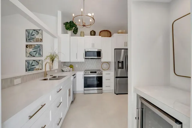 a kitchen with stainless steel appliances a sink stove and refrigerator