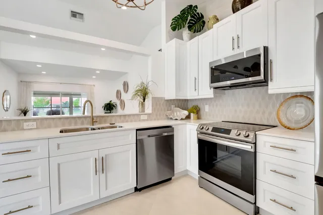 a kitchen with white cabinets and stainless steel appliances