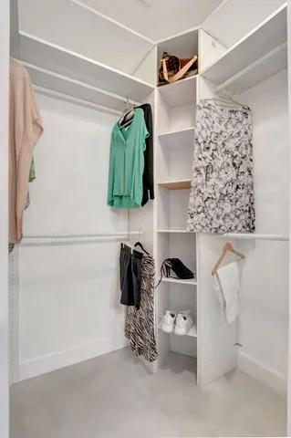 a view of walk in closet with clothes and shoes