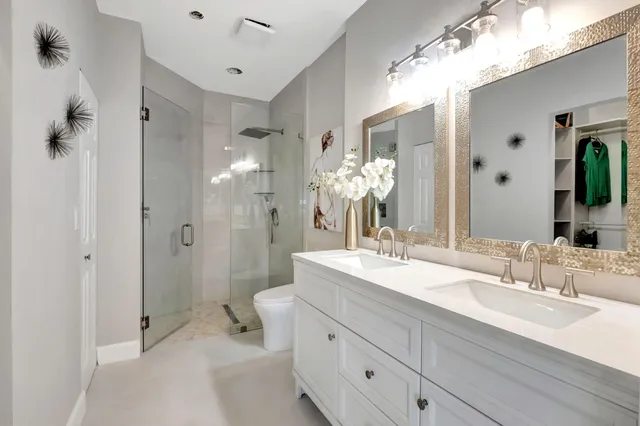 a bathroom with a double vanity sink mirror and shower